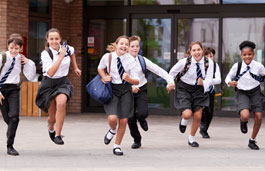 A group of mixed gender and ethnicity high school children running and laughing together.