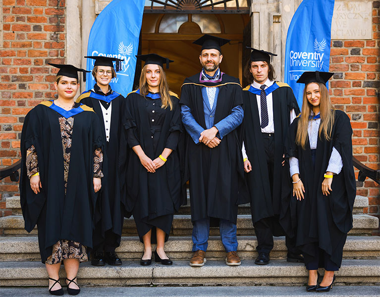 graduates standing out side of university building on a clear day