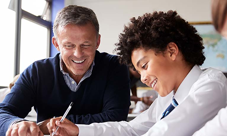 school teacher helping a student in a classroom