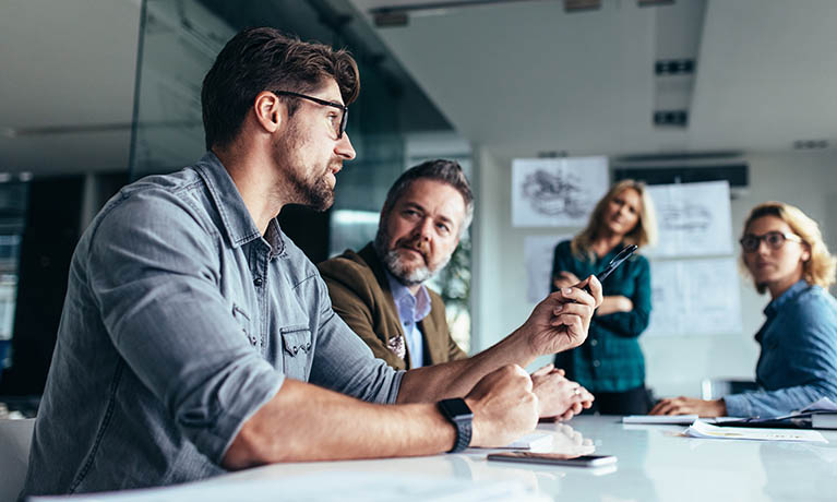 Group of people sat around a table talking