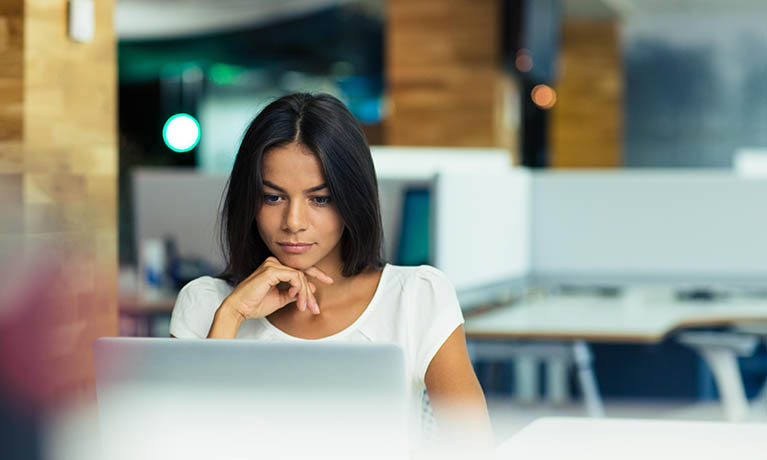 A woman looking at a laptop screen