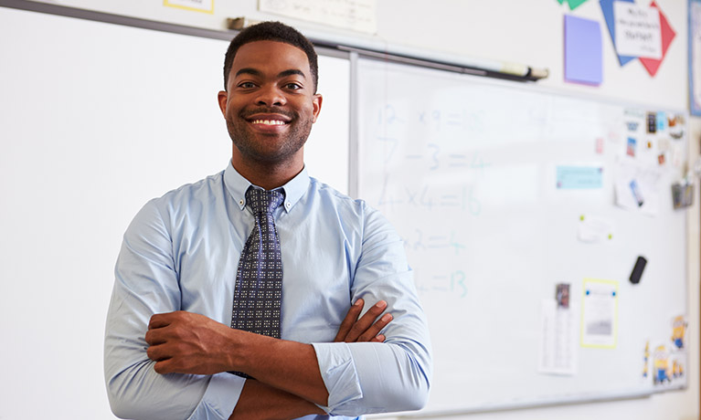Male teacher stood in front of white board