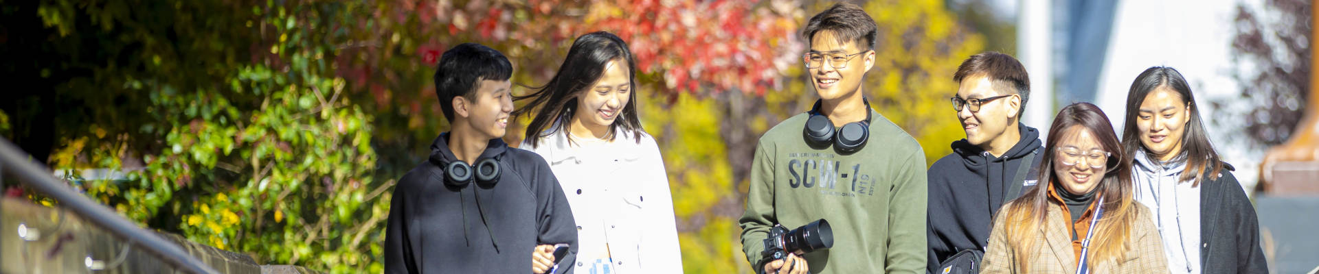 Group of students smiling walking down path