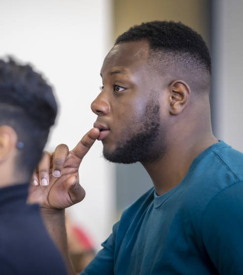 Lecturer stood at the front of a classroom talking to students