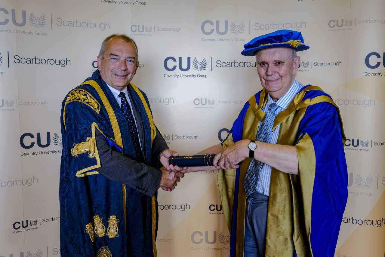 John Latham presenting a scroll to male student