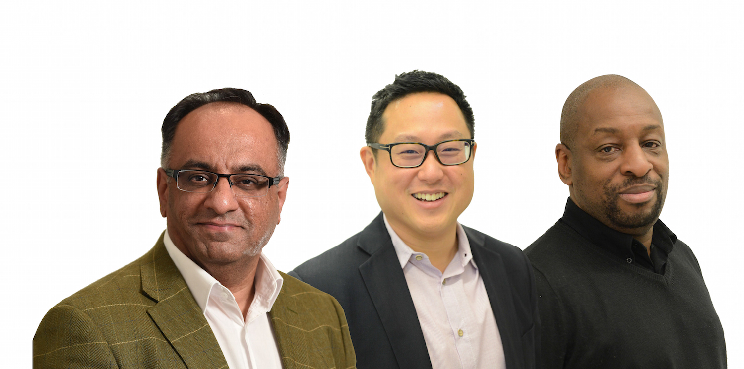 Three men in suits smiling