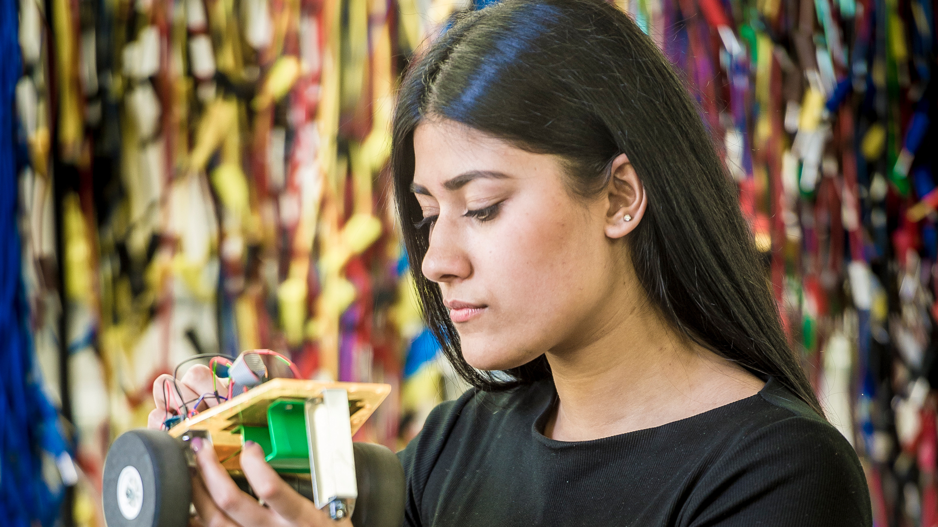 Female student working on a small model car