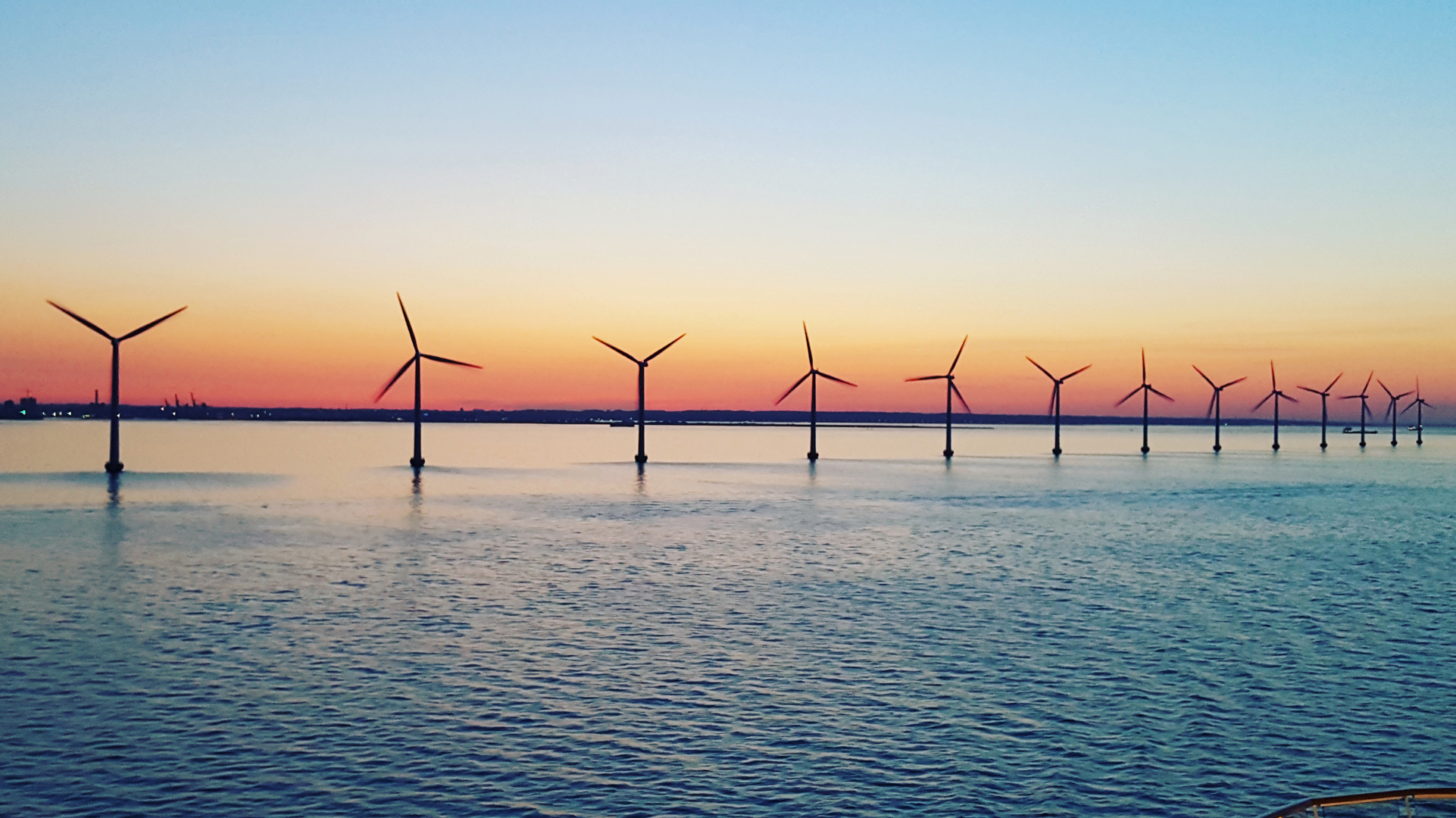 Wind turbines in the sea at sunset.