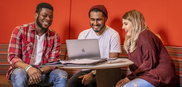 students sitting looking at a laptop