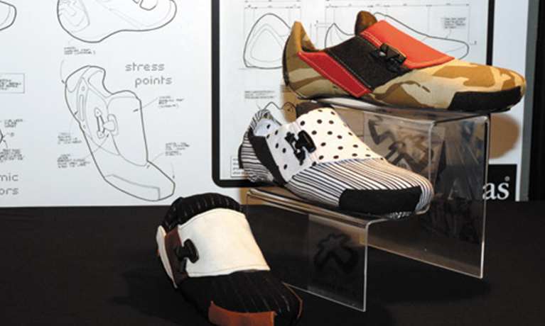 Sketches of shoes with a stand of three different shoes in front